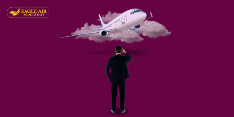 A man in a suit standing in front of an airplane covered in clouds.