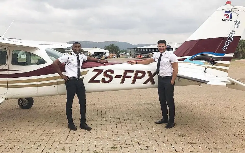 Two Eagle Air Pilots Standing Next To An Aircraft